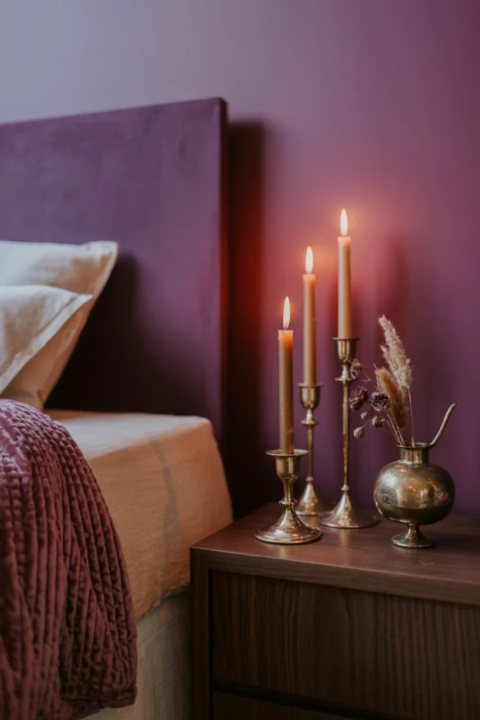 Moody bedroom with velvet throw, brass candlesticks, and dried florals