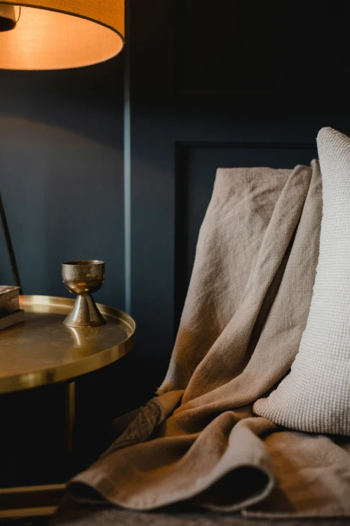 Moody living room corner showing a locked jewel-tone, brass, and linen palette