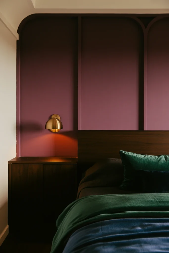deep plum accent wall in whimsigoth bedroom with brass accents
