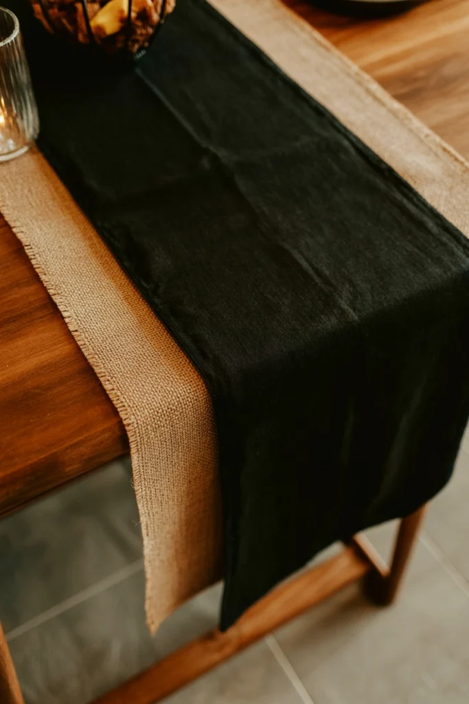Black table runner layered under Halloween centerpiece