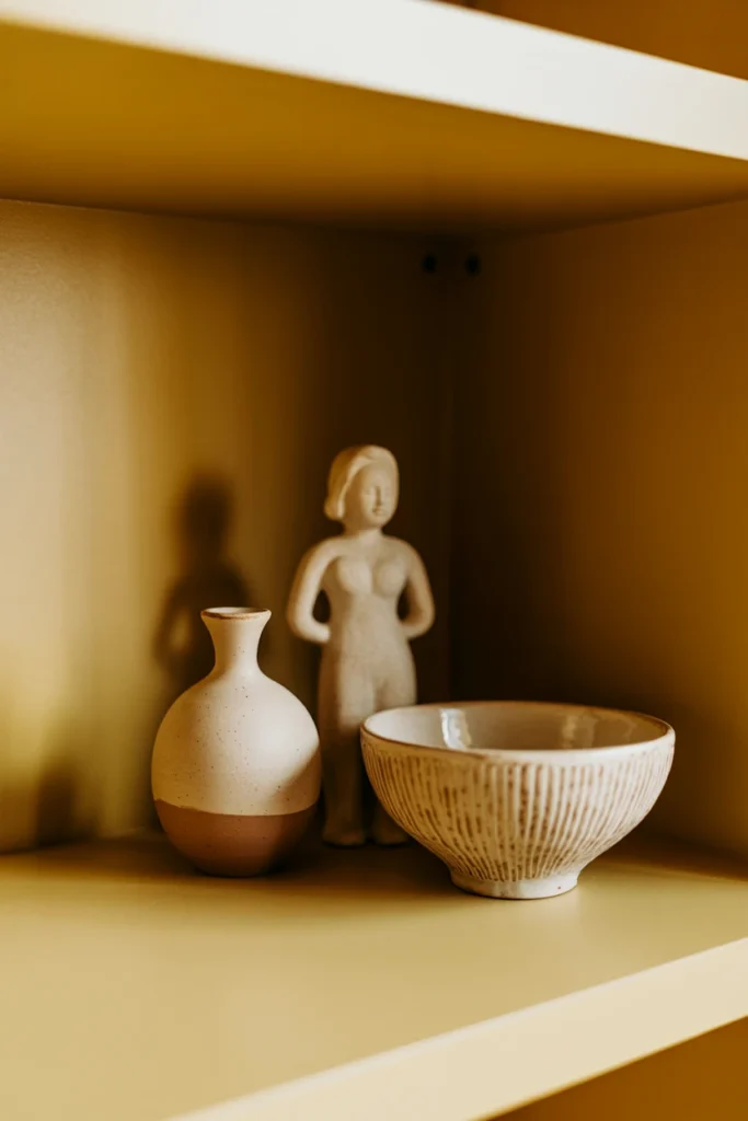 Vignette of three ceramic objects grouped on shelf at varied heights