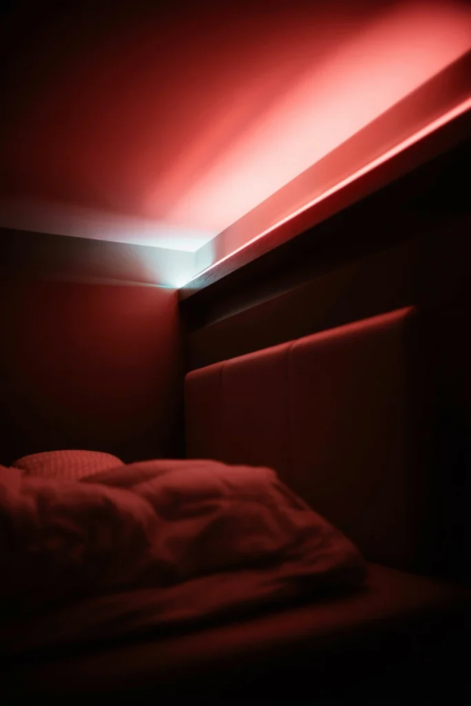 Pink neon LED strip lighting installed along the ceiling edge of an 80s bedroom