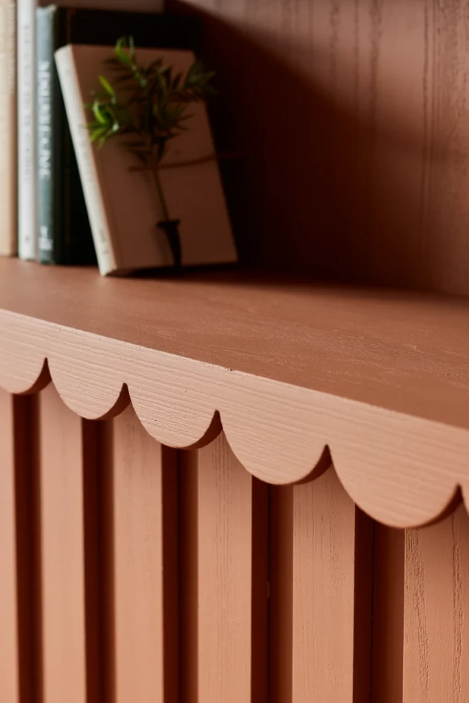 Shelf edge with scalloped wooden trim painted in accent color