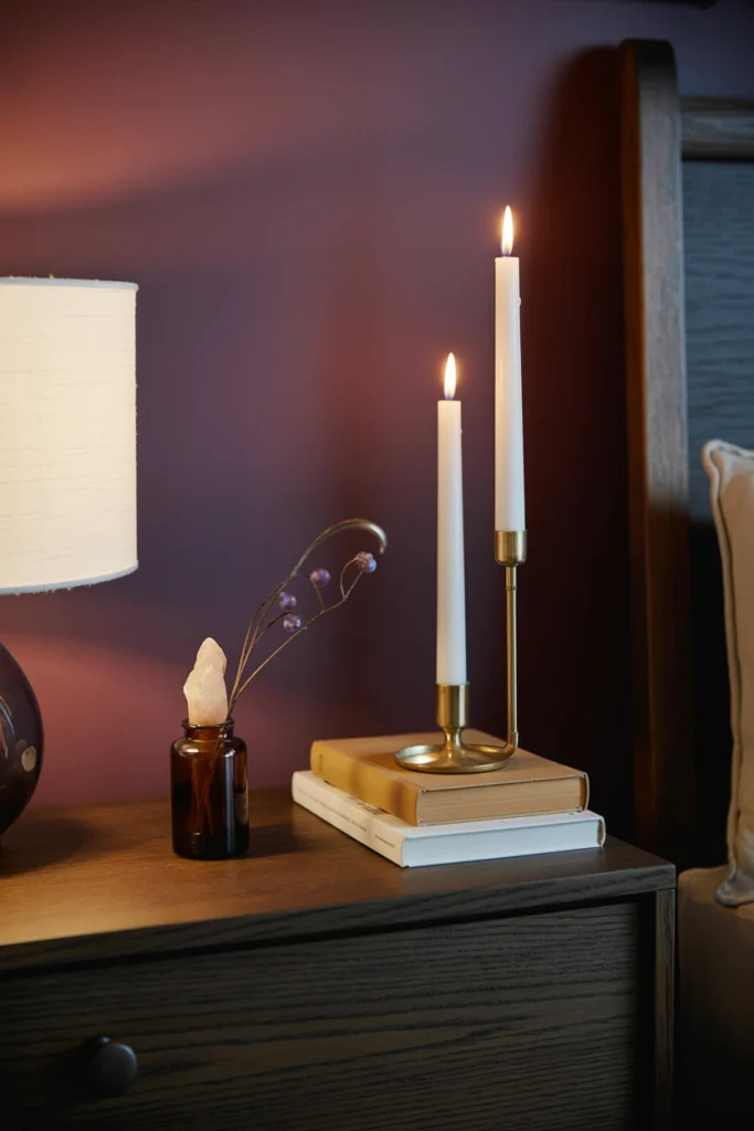 nightstand styled with candle, book, and small vase in threes