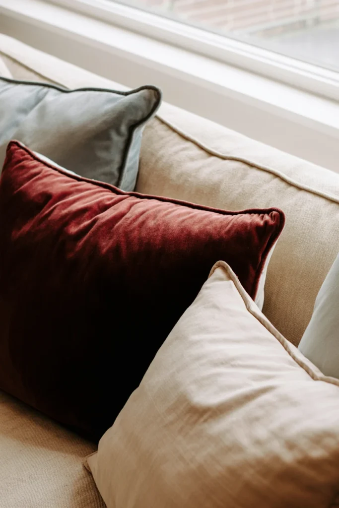 Velvet throw pillows mixed with linen cushions on a sofa