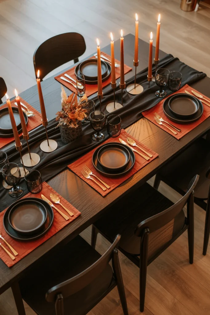Black table runner with orange placemats set for Halloween dinner