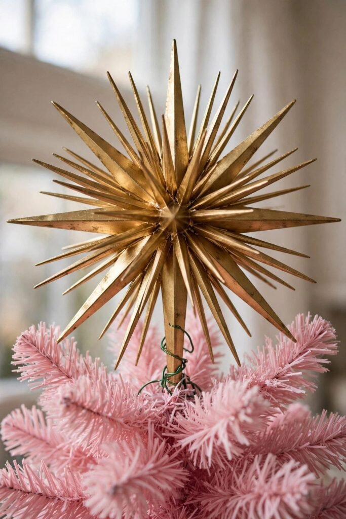 Oversized gold starburst topper on top of a pink Christmas tree