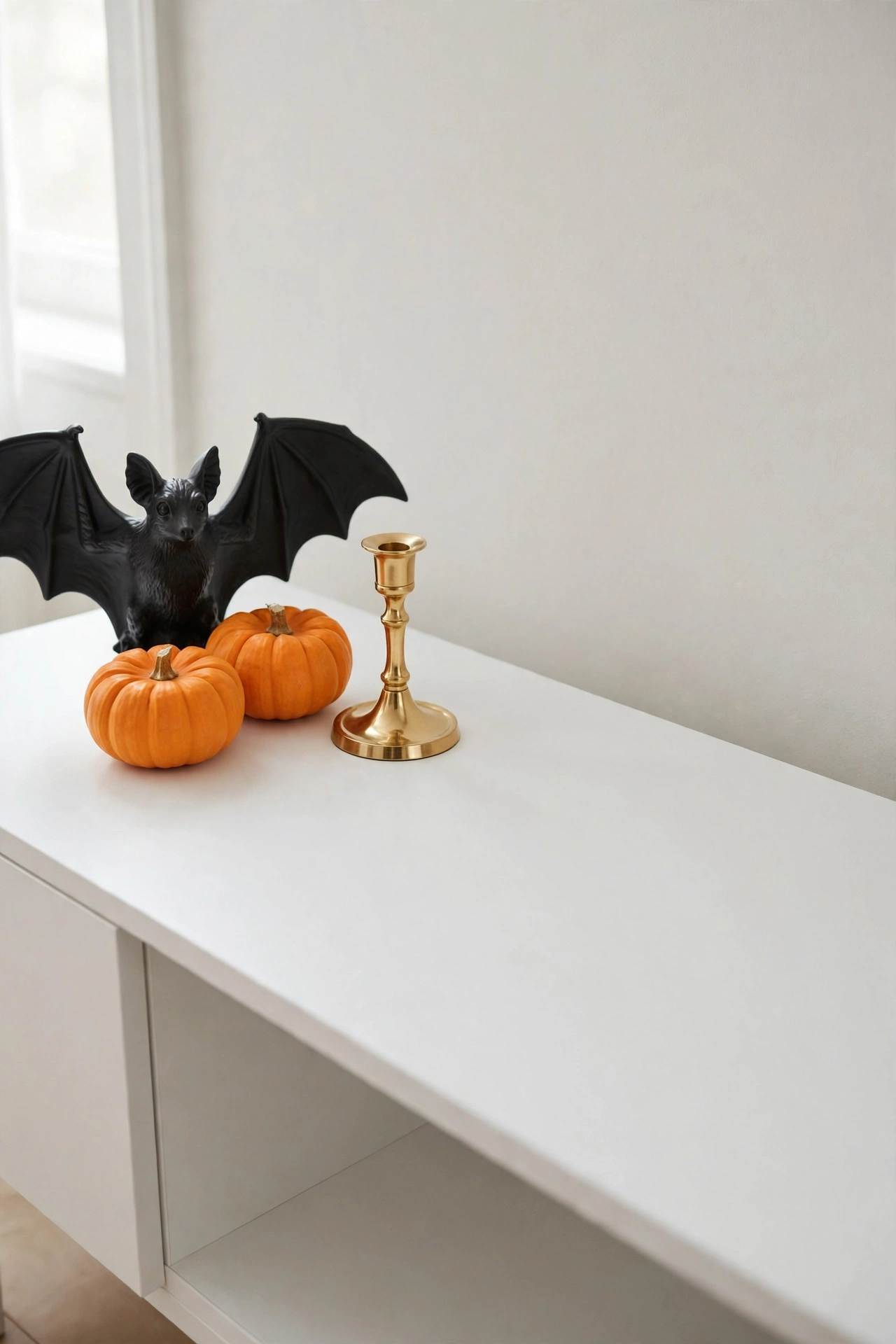 Cleared console table styled with three Halloween props and open negative space